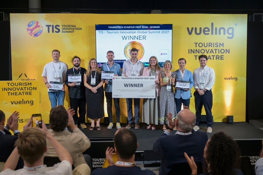 Prisoverrækkelsen ved Touristech Startup Fest 2026 på scenen til TIS i Sevilla, med WINNER-skiltet i midten